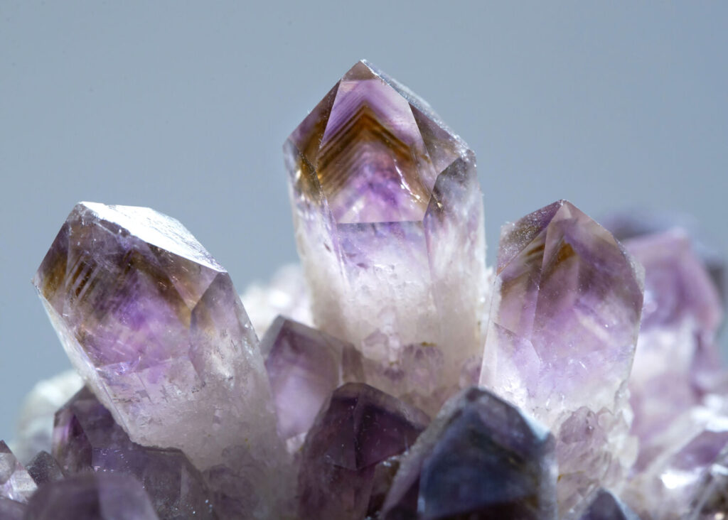 アメトリンのイメージ写真です / A macro shot of shiny ametrine mineral specimen stone rock geology gem crystal with  a blue background