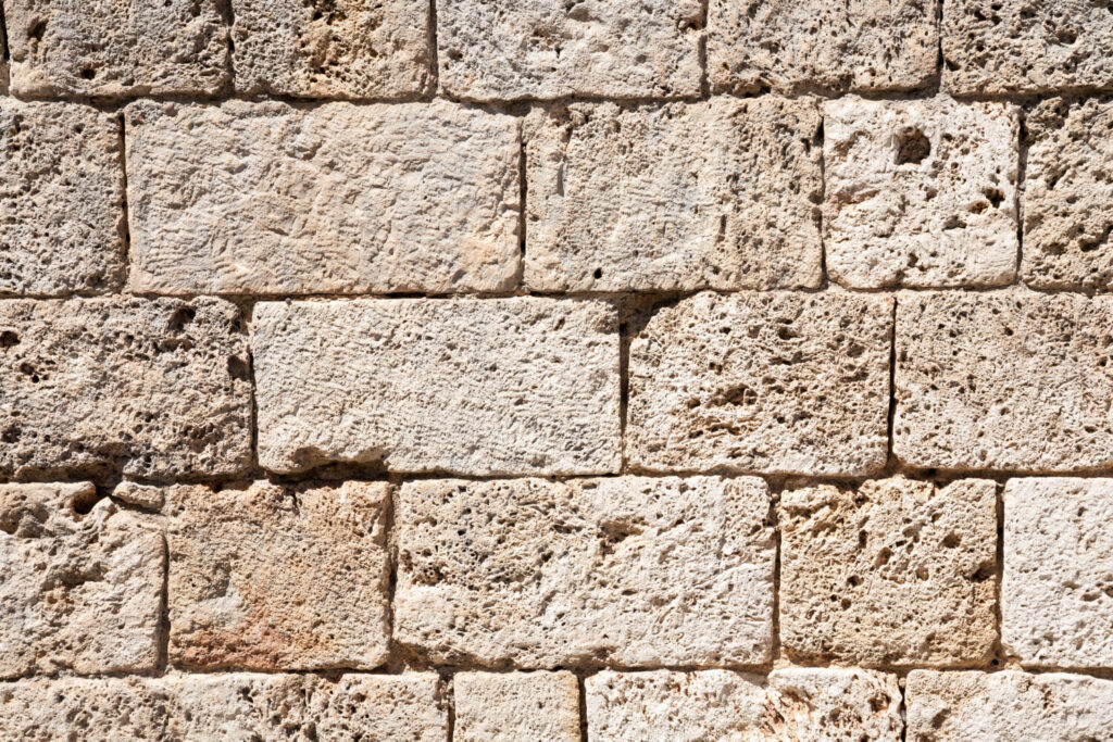 凝灰岩のイメージ写真です / A background with an italian wall made of old textured tuff blocks